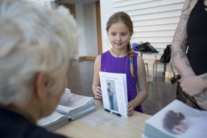 little girl holding pamphlet