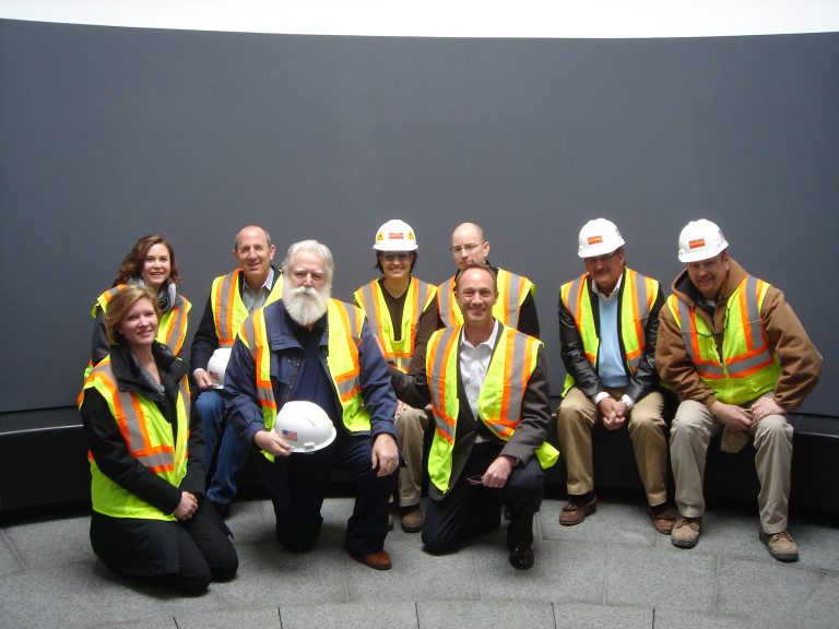 group of people sitting down in a row looking straight ahead