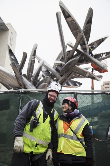 two people standing together against fence